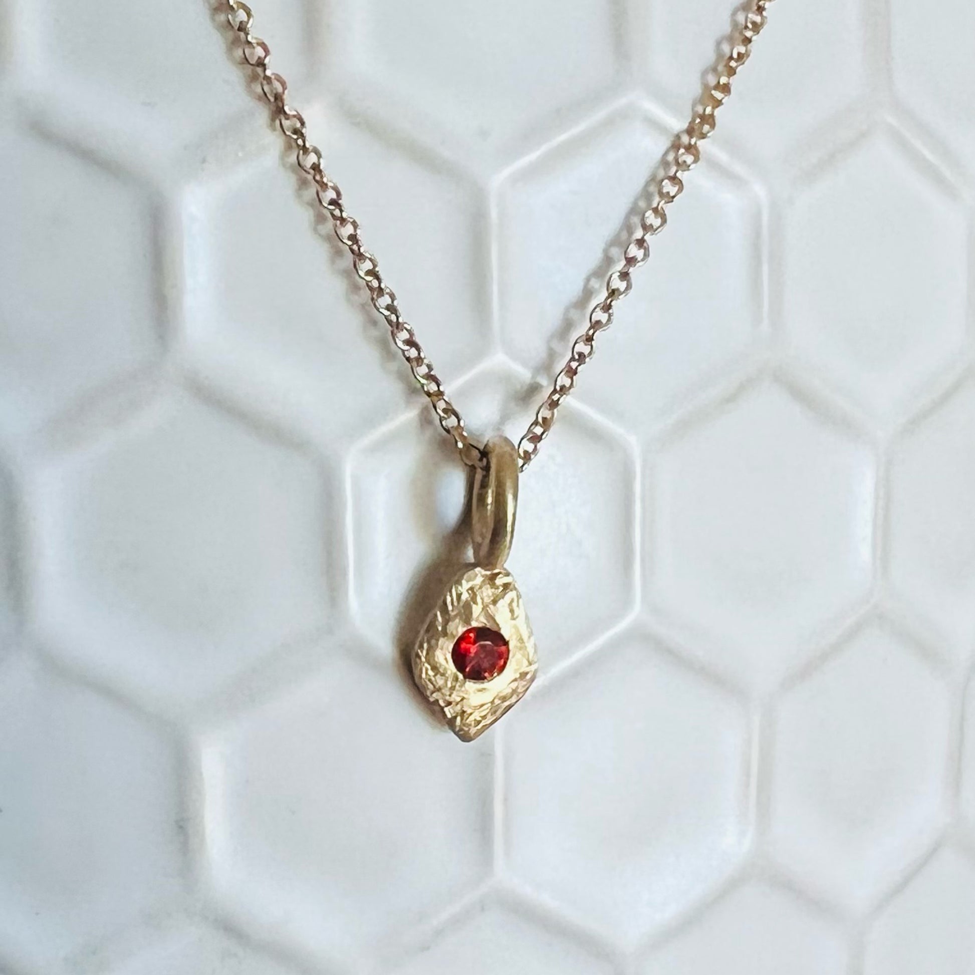 Tiny Santos Garnet Charm on White